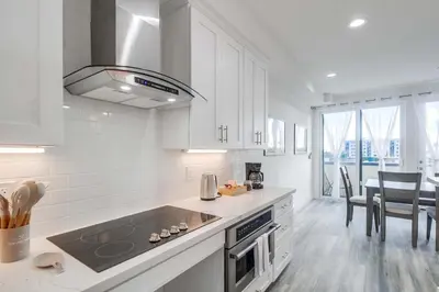 a kitchen with white cabinets and a stove top oven at Park Blvd 302 - Newly Built - Spa - Central in San Diego