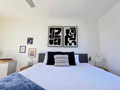 a bedroom with a white bed and two pictures on the wall at Park Blvd Paradise 303 king bed With a private Spa in San Diego