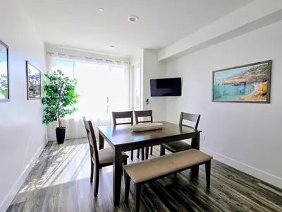 a dining room with a table and chairs and a tv at Park Blvd Paradise 303 king bed With a private Spa in San Diego