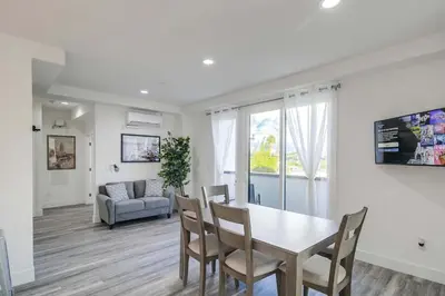 a dining room and living room with a table and chairs at Park Blvd Paradise 304 New construction, king bed! in San Diego