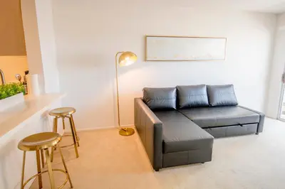 a living room with a couch and a table and stools at Bay Views & Gaslamp/Little Italy/Convention 1BD in San Diego