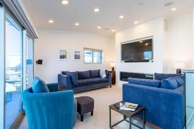 a living room with two blue couches and a tv at Ocean view, two-level condo with stunning view, decks, fast WiFi & fireplace in San Diego
