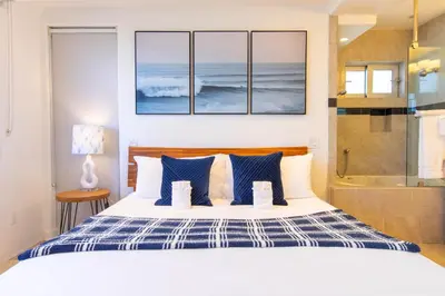 a bedroom with a bed with blue and white pillows at Ocean view, two-level condo with stunning view, decks, fast WiFi & fireplace in San Diego