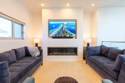 a living room with two couches and a fireplace at Ocean view, two-level condo with stunning view, decks, fast WiFi & fireplace in San Diego