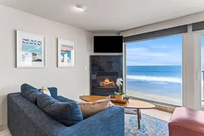 a living room with a blue couch and a fireplace at A Wave From It All in Carlsbad