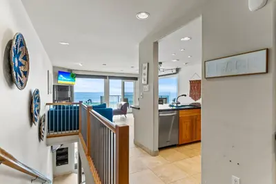 a kitchen and living room with a view of the ocean at A Wave From It All in Carlsbad