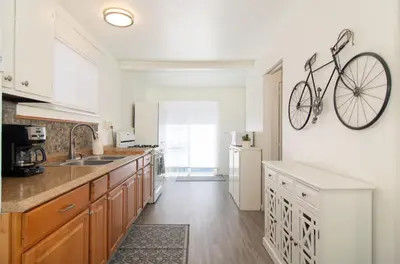 a kitchen with a bike hanging on the wall at Mission Bay Cottage - Bay View Patio, Parking, WasherDryer in San Diego