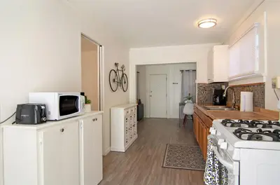 a kitchen with a microwave and a stove top oven at Mission Bay Cottage - Bay View Patio, Parking, WasherDryer in San Diego
