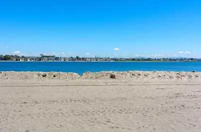 a pile of sand on a beach next to the water at Mission Bay Cottage - Bay View Patio, Parking, WasherDryer in San Diego