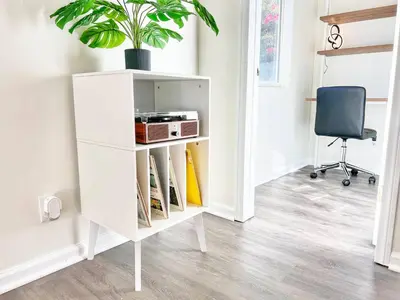 a white cabinet with a radio and a chair at Groovy Getaway Retro Vibes in North Park, SD in San Diego