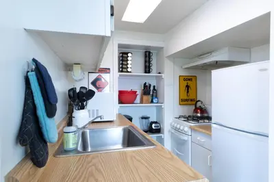 a small kitchen with a sink and a refrigerator at Spacious Ocean View Blufftop Compound in San Clemente