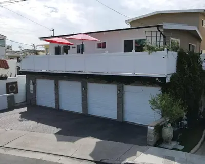 a house with four garage doors and a balcony at Sea View Escape Unit #2 in San Clemente