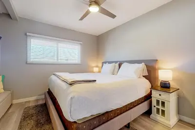 a bedroom with a bed and a ceiling fan at Blue Wave Penthouse in San Diego