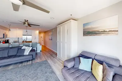 a living room with two couches and a kitchen at Blue Wave Penthouse in San Diego