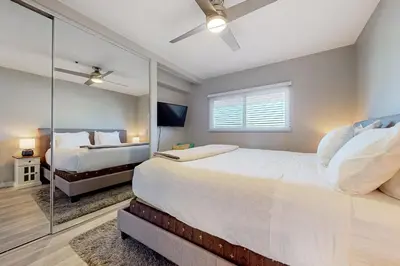 a bedroom with two beds and a mirror at Blue Wave Penthouse in San Diego