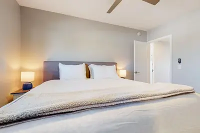 a bedroom with a large white bed with two lamps at Blue Wave Penthouse in San Diego