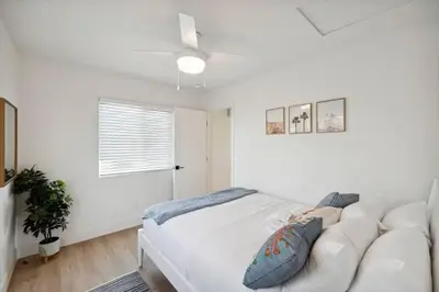 a white bedroom with a white couch and a window at Coastal Living at its Finest Pacific Beach in San Diego