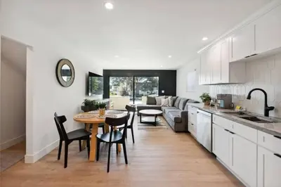 a kitchen and living room with a table and a couch at Coastal Living at its Finest Pacific Beach in San Diego