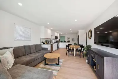 a living room with a couch and a table and a kitchen at Coastal Living at its Finest Pacific Beach in San Diego