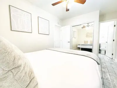 a white bedroom with a bed and a bathroom at Modern Retreat Just Outside The City in San Diego