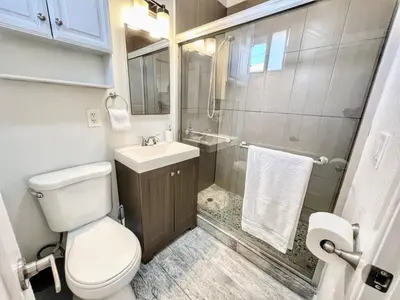 a bathroom with a toilet and a sink and a shower at Charming Flat Near the City in San Diego