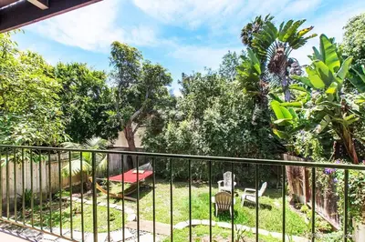 a balcony with a fence and chairs and trees at Coastal Paradise Blocks from Beacon's Beach in Encinitas