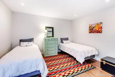 a bedroom with two beds and a rug at Coastal Paradise Blocks from Beacon's Beach in Encinitas