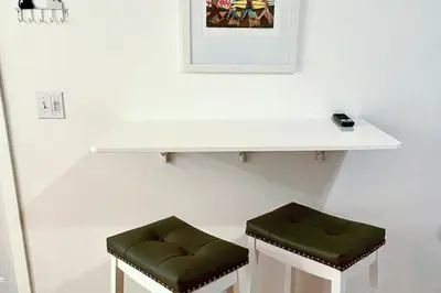 two green stools sitting under a white shelf at Sandcastle Cottage 22 in Oceanside