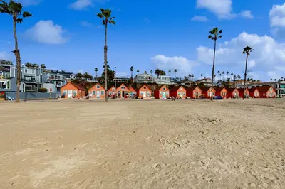 a sandy beach with red houses and palm trees at Sandcastle Cottage 22 in Oceanside