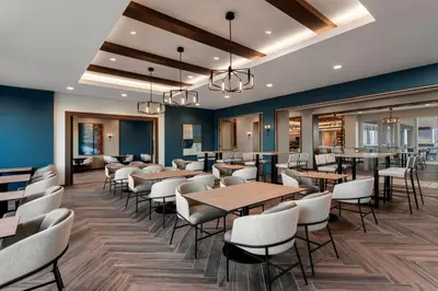 a dining room with tables and white chairs at SpringHill Suites by Marriott Chula Vista Eastlake in Chula Vista