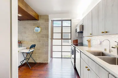 a kitchen with a sink and a chair in it at Seaside Serenity Haven -30 night min in San Diego