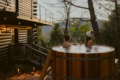 a couple of people sitting in a hot tub at Award-Winning A-Frame with Views and Cedar Hot Tub in Julian