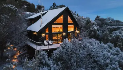 a house on the side of a snow covered mountain at Award-Winning A-Frame with Views and Cedar Hot Tub in Julian