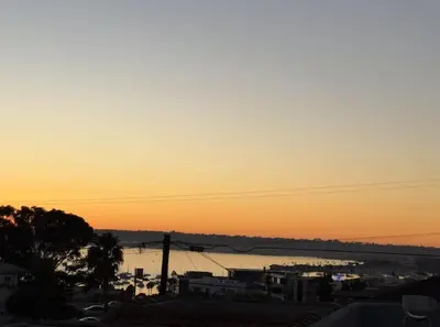 a sunset over a body of water with a city at Charming Guest House in SD in San Diego