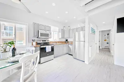a kitchen with white appliances and a table and chairs at Stunning Ocean Views - Recently Renovated Home & Warm Sunsets in San Diego