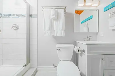 a white bathroom with a toilet and a shower at Stunning Ocean Views - Recently Renovated Home & Warm Sunsets in San Diego