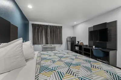 a hotel room with a bed and a desk at Studio 6 Suites Perris, CA in Perris