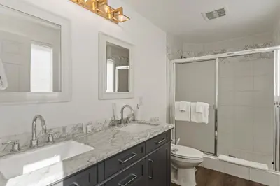 a white bathroom with two sinks and a toilet at Oceanfront 3-unit complex - Private Deck - BBQ in Oceanside