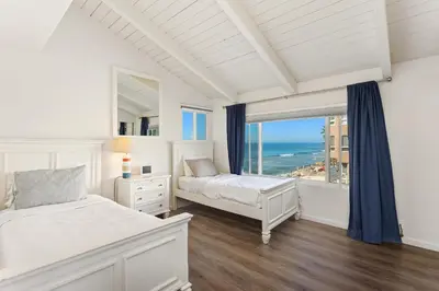 a bedroom with two beds and a window with the ocean at 2BR Oceanfront Condo - Private Balcony - Spacious in Oceanside