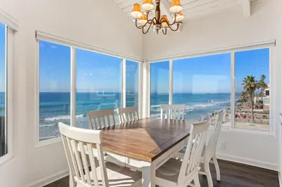a dining room with a table and views of the ocean at 2BR Oceanfront Condo - Private Balcony - Spacious in Oceanside