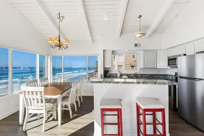 a kitchen with a table and chairs and the ocean at 2BR Oceanfront Condo - Private Balcony - Spacious in Oceanside