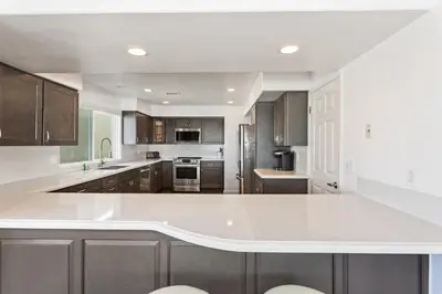 a large kitchen with a large white counter top at Oceanfront Family Getaway - BBQ - Oceanfront Seating in Oceanside