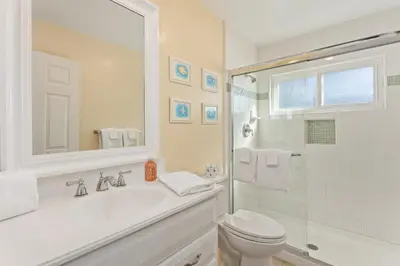 a white bathroom with a sink and a toilet at Oceanfront Family Getaway - BBQ - Oceanfront Seating in Oceanside