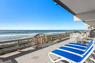 a deck with blue and white chairs and the ocean at Oceanfront Family Getaway - BBQ - Oceanfront Seating in Oceanside