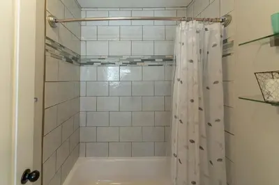 a bathroom with a shower with a white shower curtain at Not taking reservations in Chula Vista
