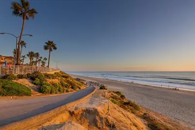 a road leading to a beach with palm trees and the ocean at Walk To Beach - EV Charger - Outdoor Dining - 2BR in Carlsbad