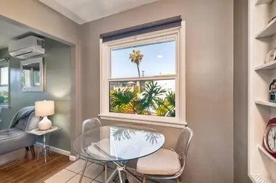 a dining room with a glass table and a window at Walk To Beach - EV Charger - Outdoor Dining - 2BR in Carlsbad