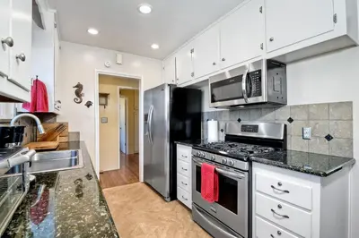 a kitchen with stainless steel appliances and white cabinets at Walk To Beach - BBQ - Fire Pit - Outdoor Dining in Carlsbad
