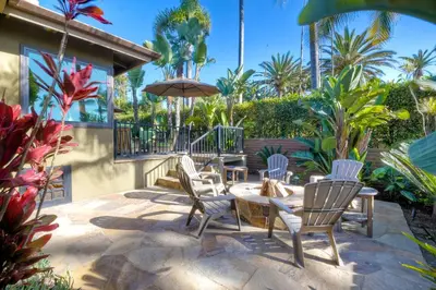 a patio with chairs and a table with an umbrella at Walk To Beach - BBQ - Fire Pit - Outdoor Dining in Carlsbad