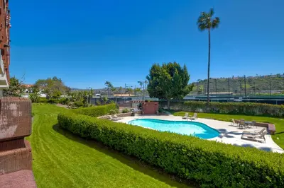 a swimming pool in a park with bushes at La Costa Luxury Condo - Fully Remodeled in Encinitas